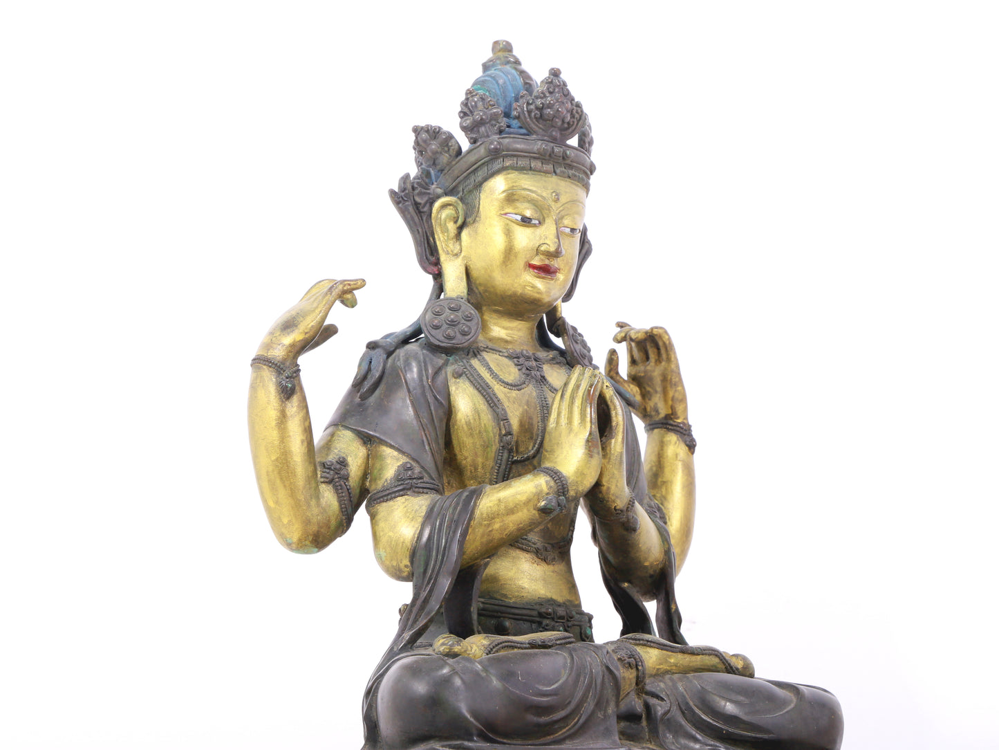 A serene gilt bronze four-armed Guanyin statue