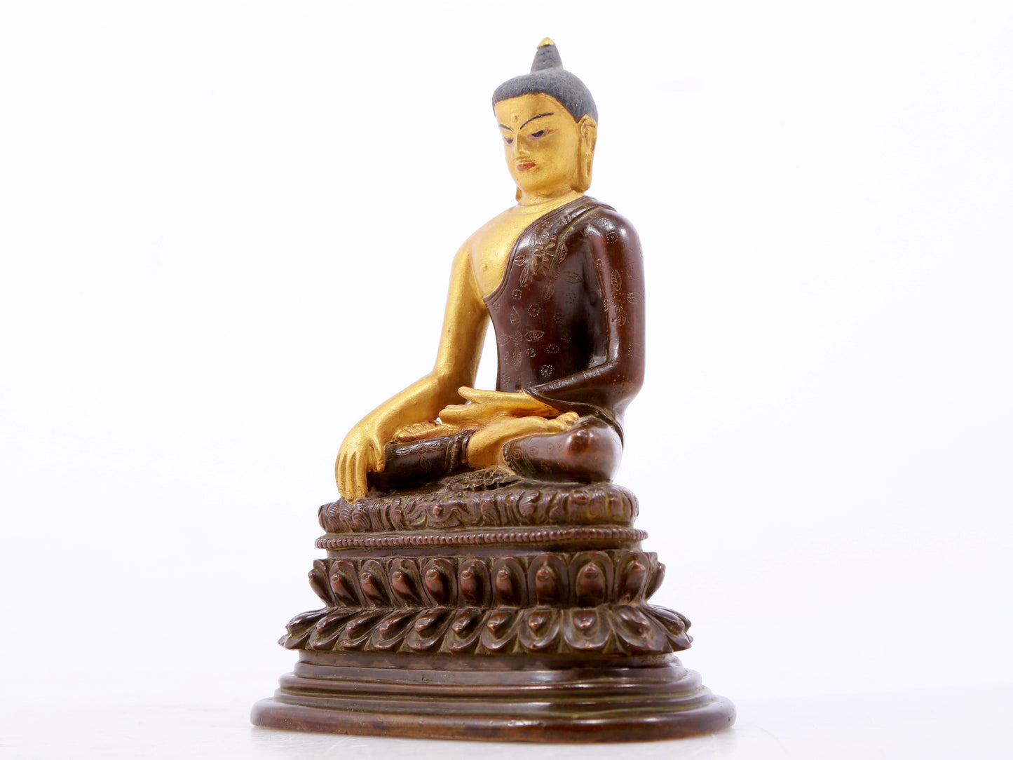 A serene gilt bronze statue of Gautama Buddha