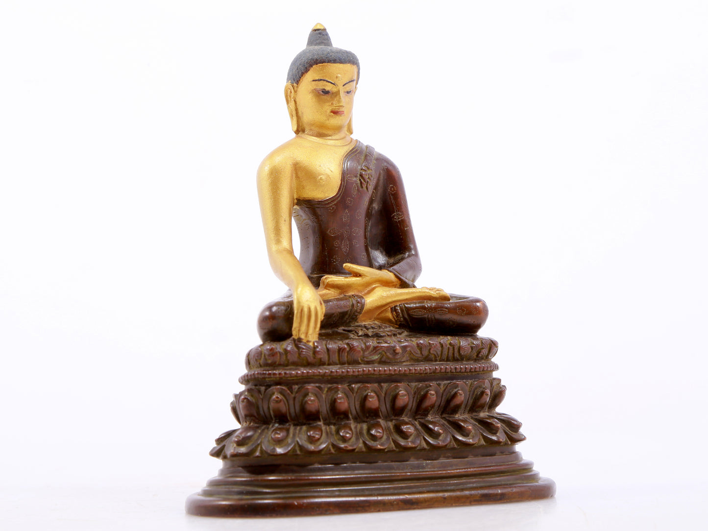 A serene gilt bronze statue of Gautama Buddha