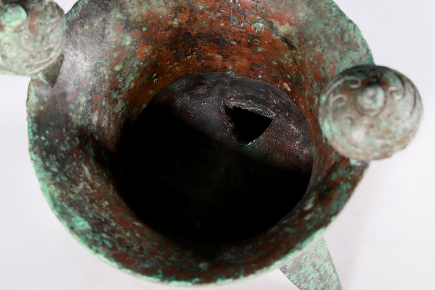 A precious bronze tripod cup with animal masks