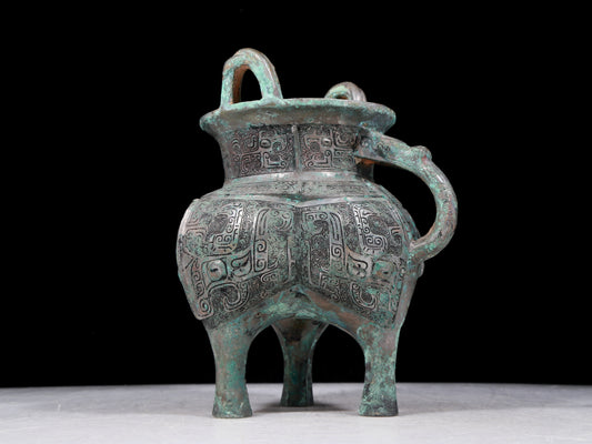 A precious bronze tripod pot with animal masks