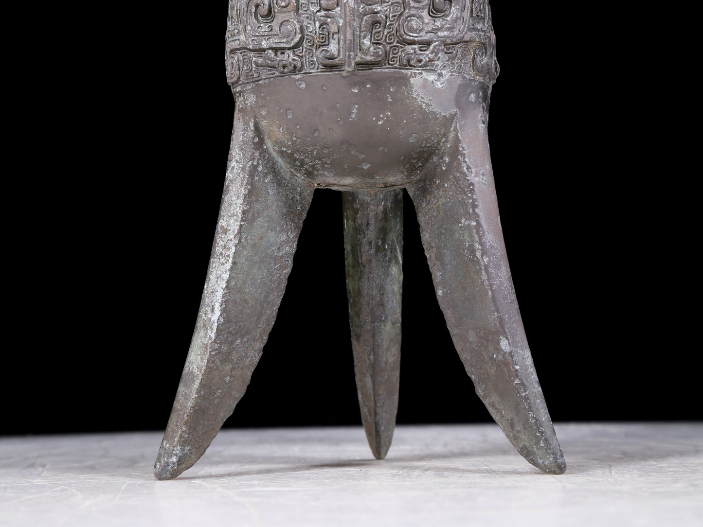 A precious bronze tripod cup with animal masks