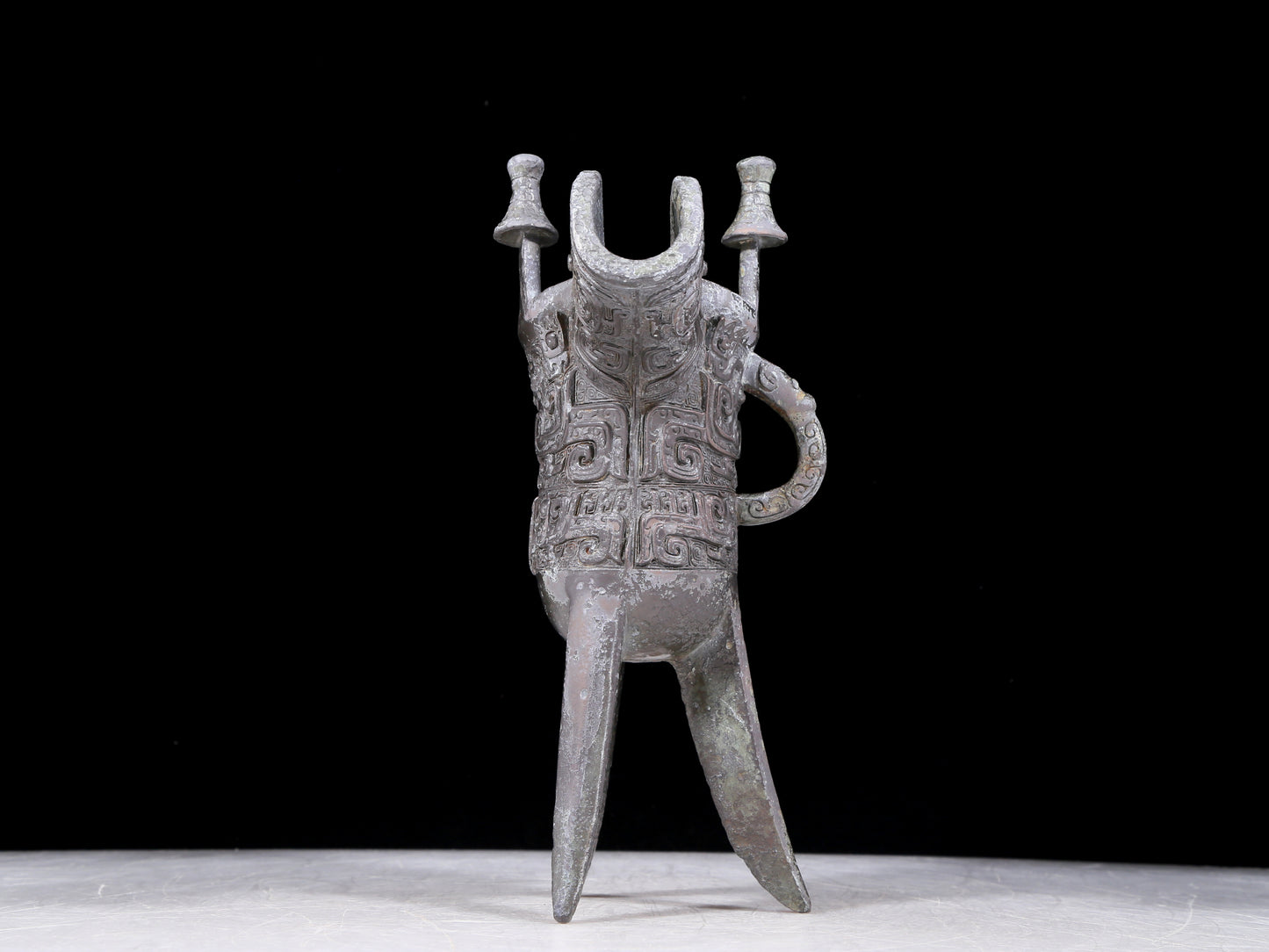 A precious bronze tripod cup with animal masks