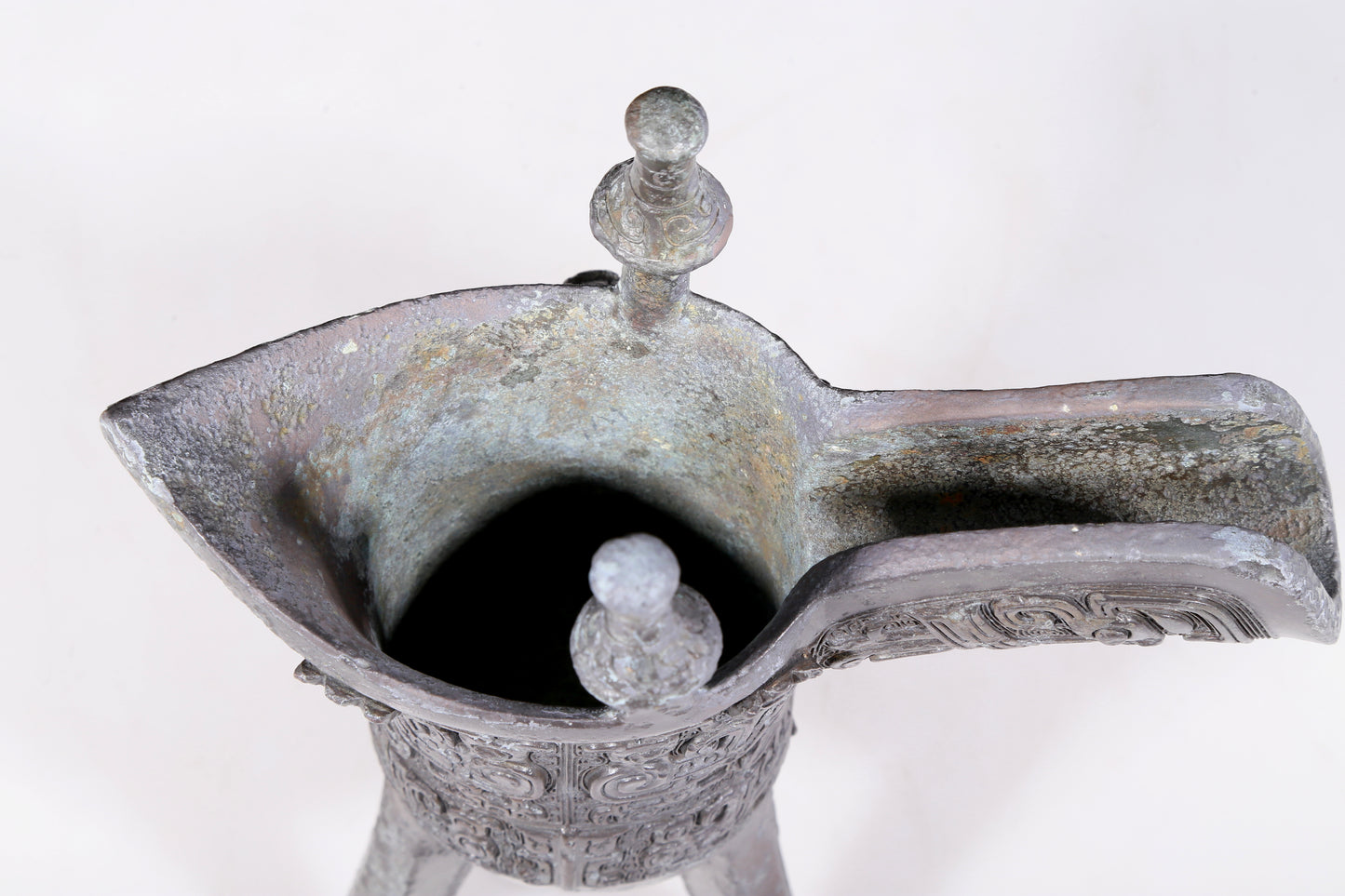 A precious bronze tripod cup with animal masks