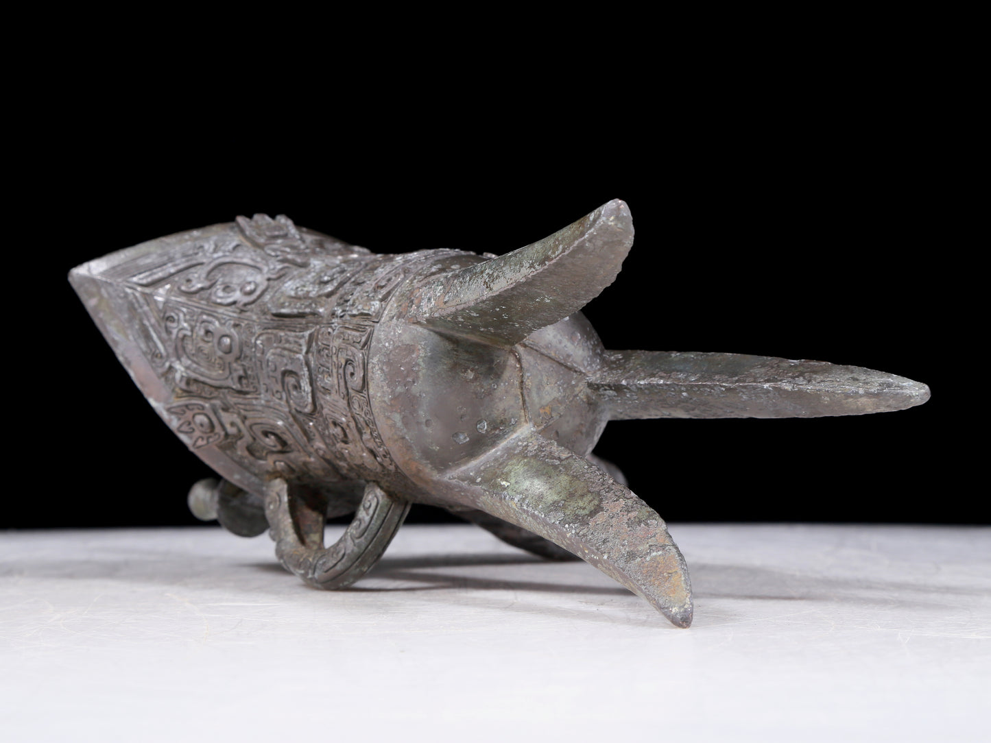 A precious bronze tripod cup with animal masks