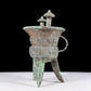 A precious bronze tripod cup with animal masks