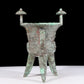 A precious bronze tripod cup with animal masks