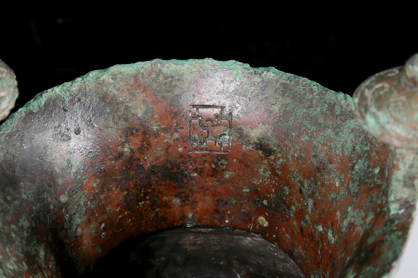 A precious bronze tripod cup with animal masks