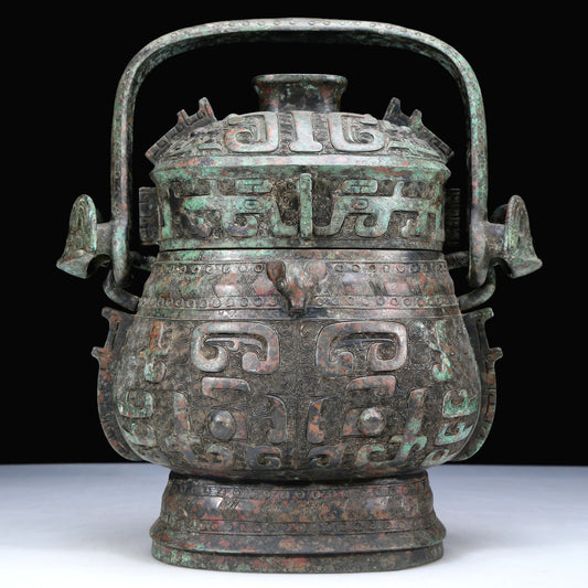 An Archaic Bronze 'Animal Mask' Pot With Inscriptions And An Overhead Handle