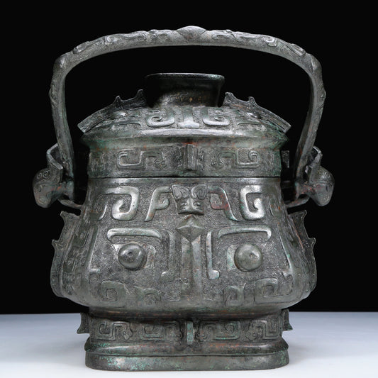 An Archaic Bronze 'Animal Mask' Pot With Inscriptions And An Overhead Handle