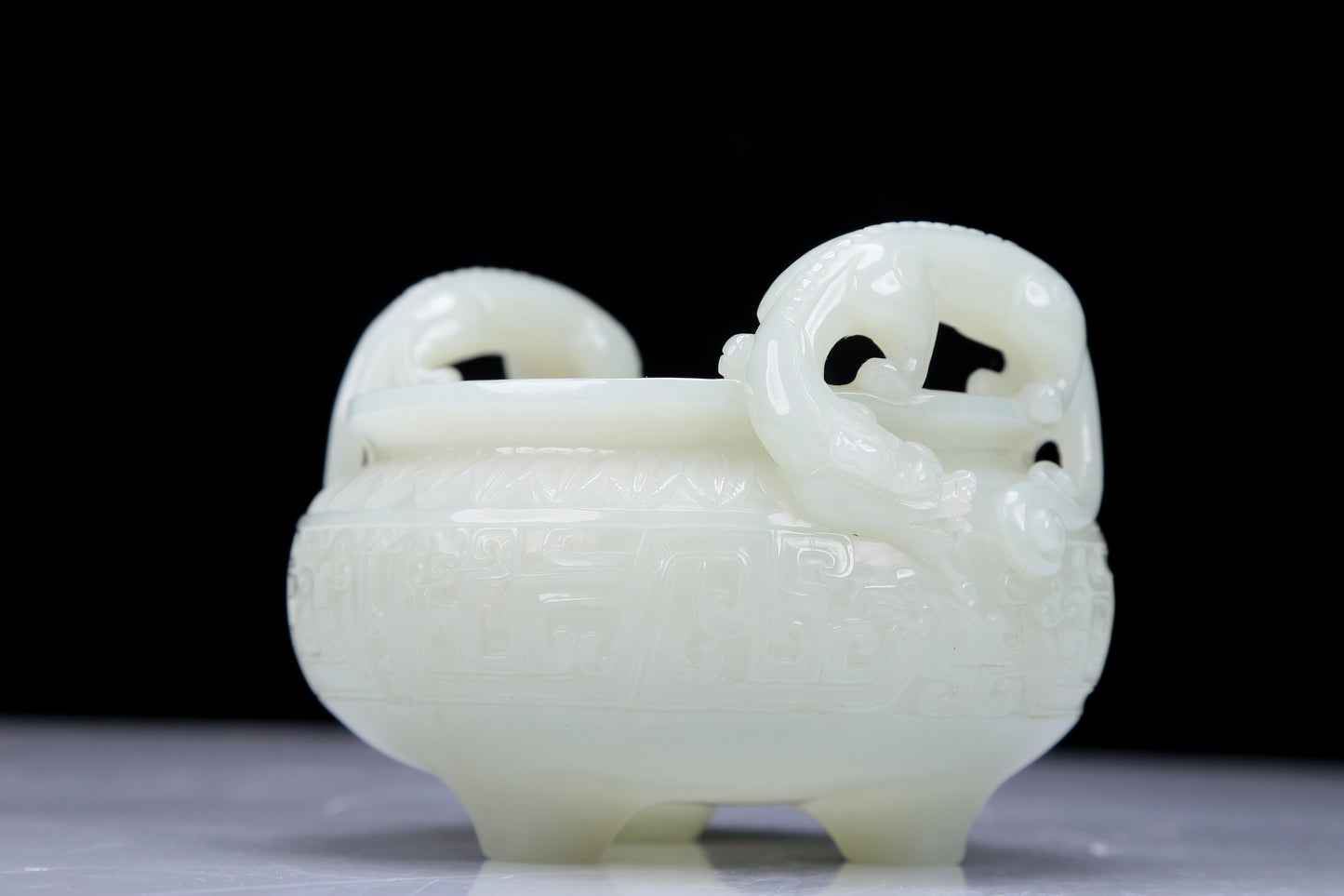 A Precious White Jade 'Dragon' Tripod Censer. Carved with archaistic motifs. Chinese Qing Dynasty. Size:11cmx7.5cm. Weight:400g     清代 白玉龙纹双耳三足炉