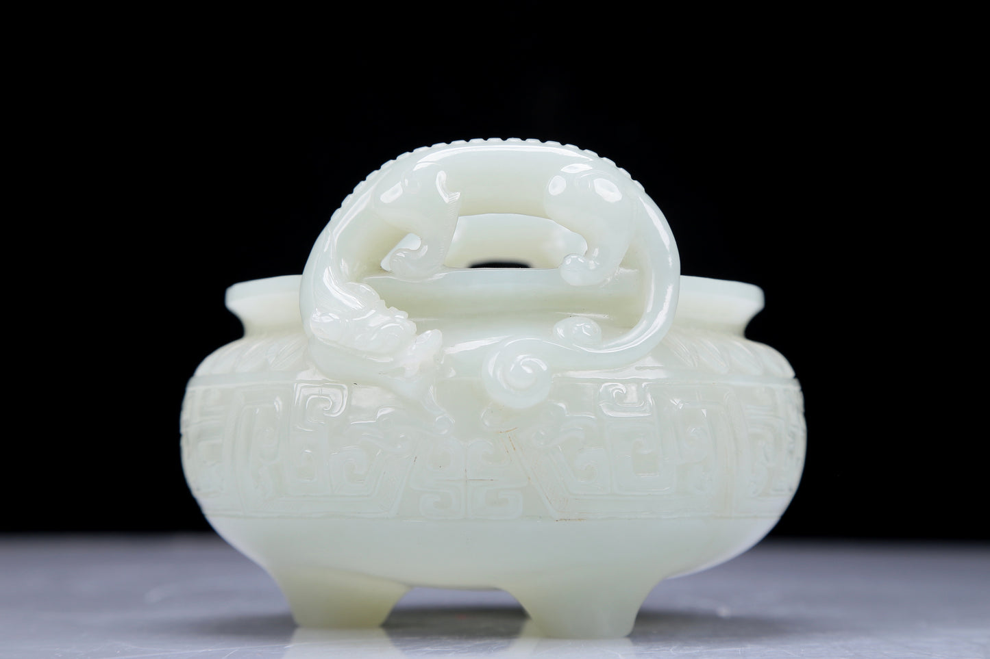 A Precious White Jade 'Dragon' Tripod Censer. Carved with archaistic motifs. Chinese Qing Dynasty. Size:11cmx7.5cm. Weight:400g     清代 白玉龙纹双耳三足炉