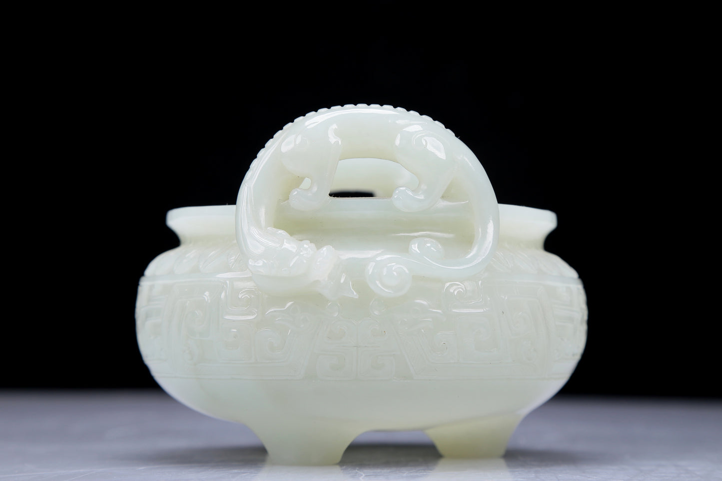 A Precious White Jade 'Dragon' Tripod Censer. Carved with archaistic motifs. Chinese Qing Dynasty. Size:11cmx7.5cm. Weight:400g     清代 白玉龙纹双耳三足炉