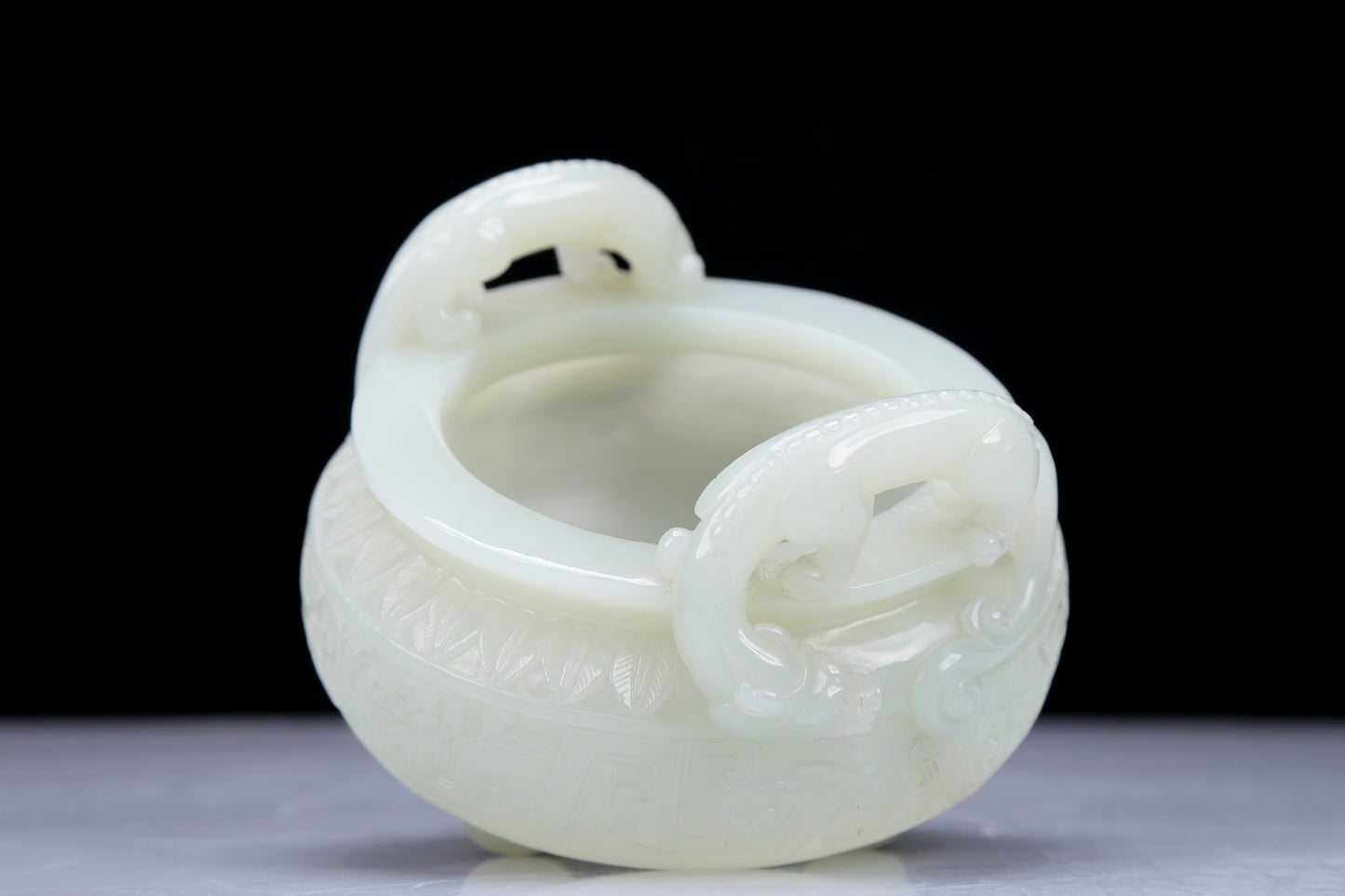 A Precious White Jade 'Dragon' Tripod Censer. Carved with archaistic motifs. Chinese Qing Dynasty. Size:11cmx7.5cm. Weight:400g     清代 白玉龙纹双耳三足炉