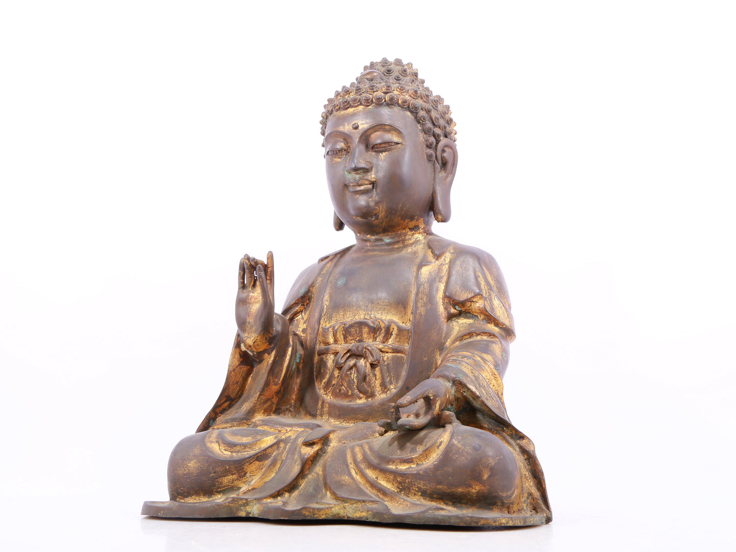 A solemn gilt bronze statue of Gautama Buddha