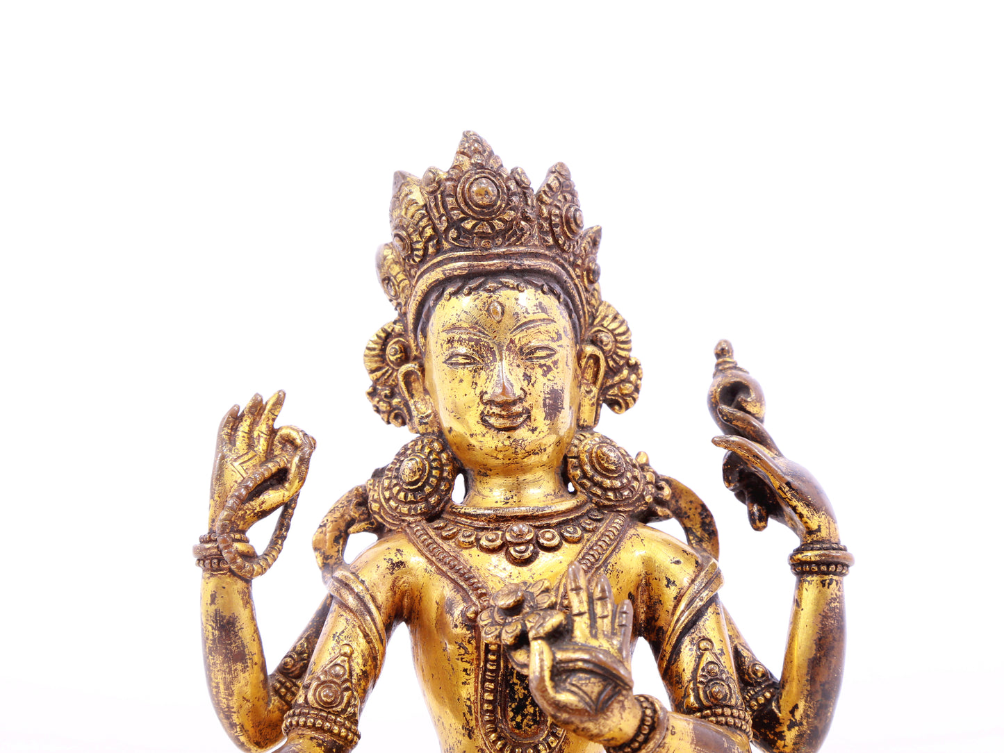 A solemn gilt bronze four-armed Guanyin statue