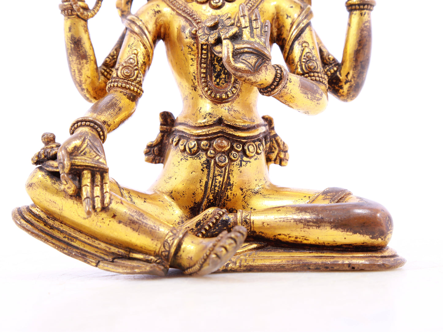 A solemn gilt bronze four-armed Guanyin statue