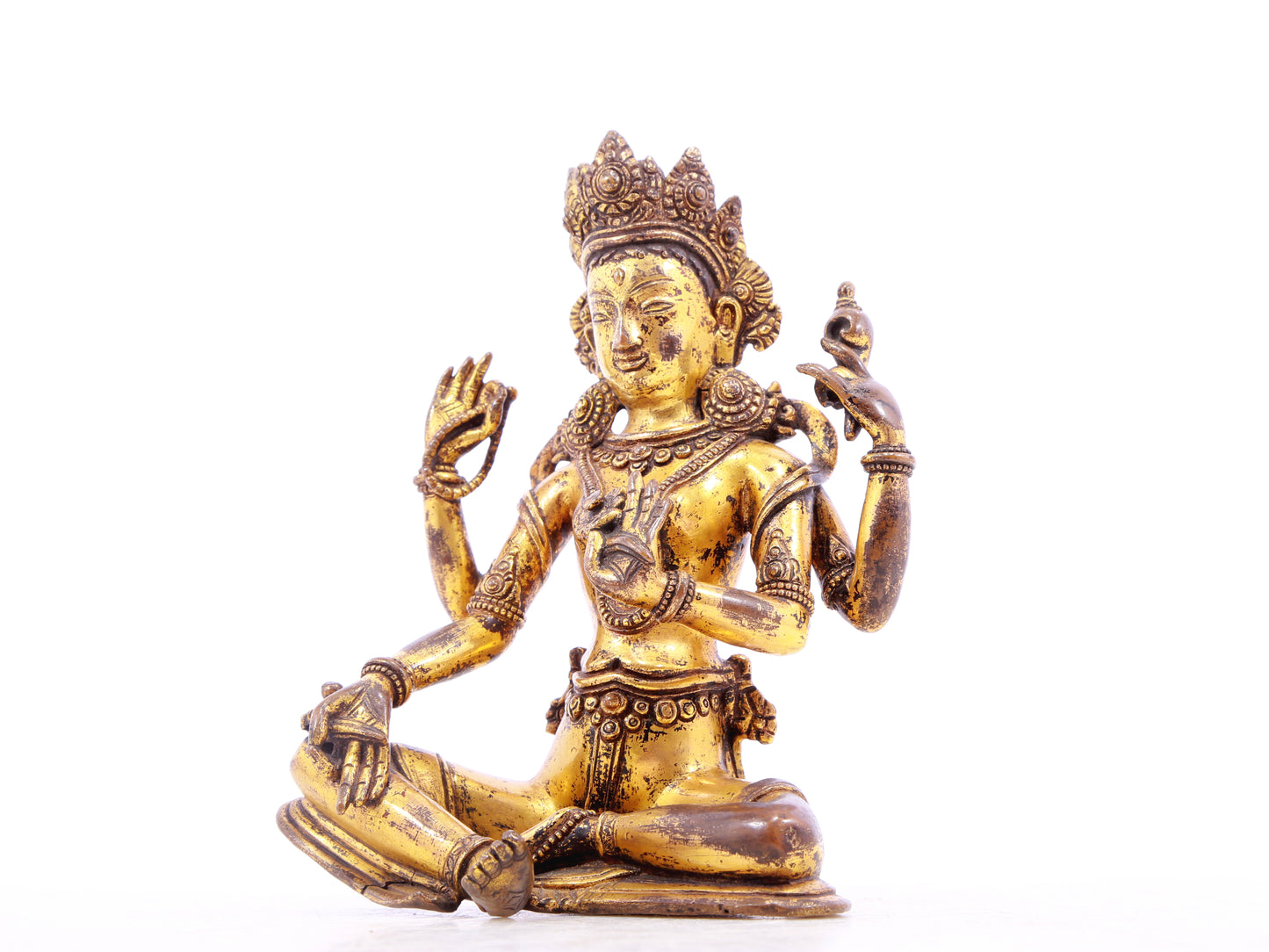 A solemn gilt bronze four-armed Guanyin statue