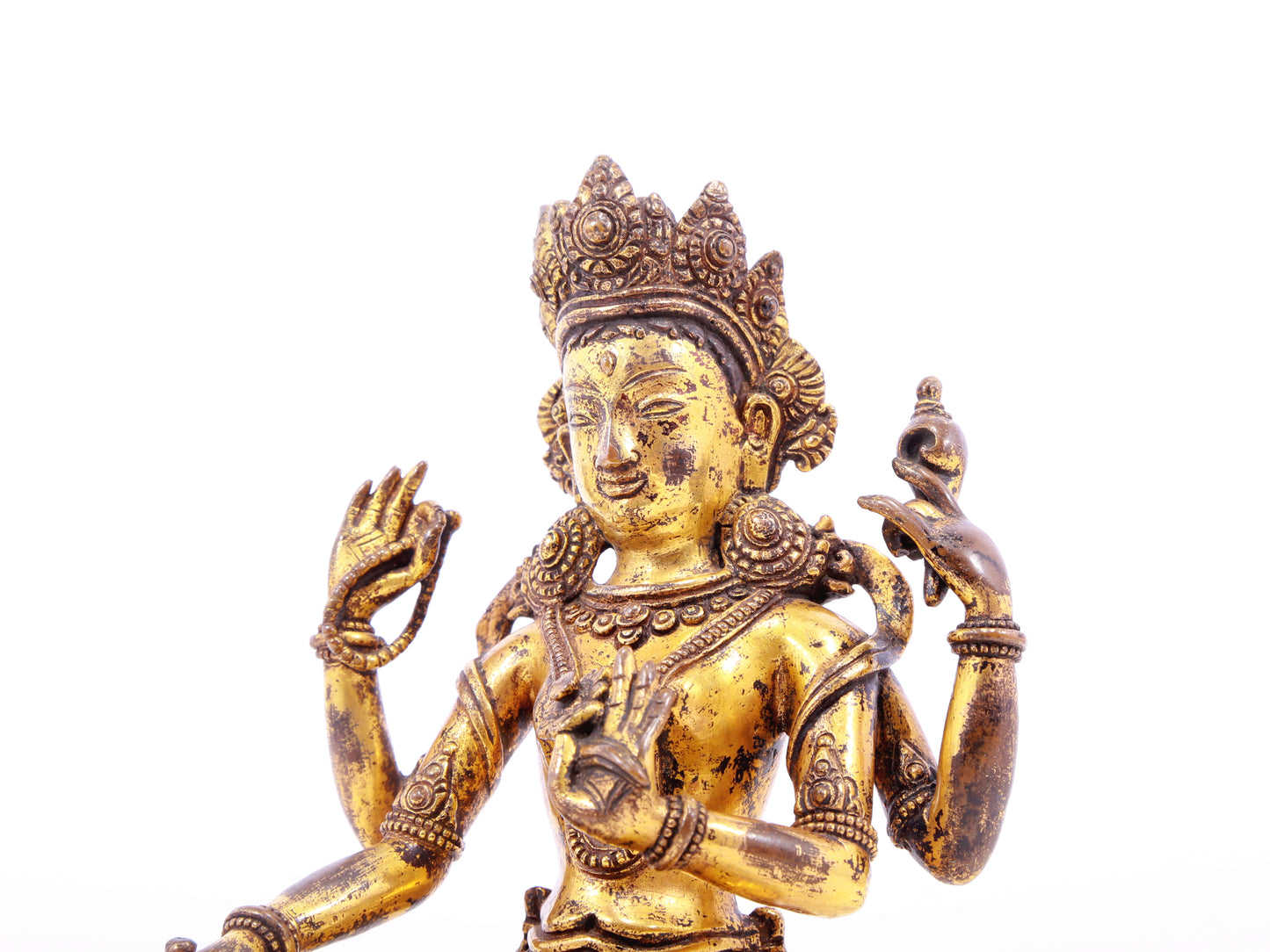 A solemn gilt bronze four-armed Guanyin statue