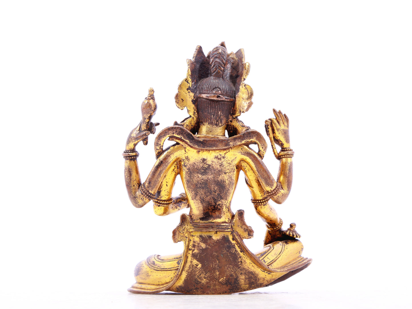 A solemn gilt bronze four-armed Guanyin statue