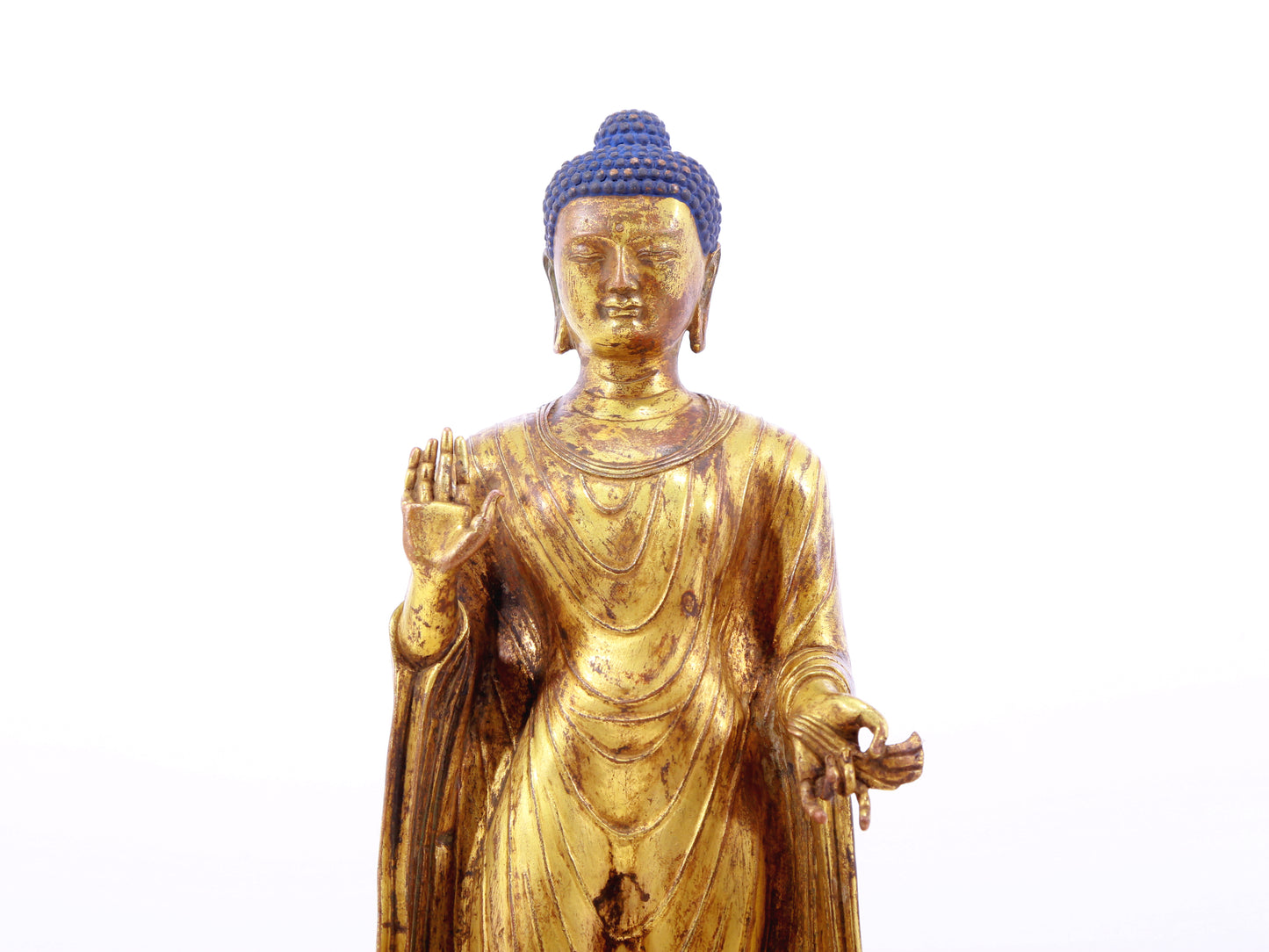 A serene gilt bronze statue of Gautama Buddha