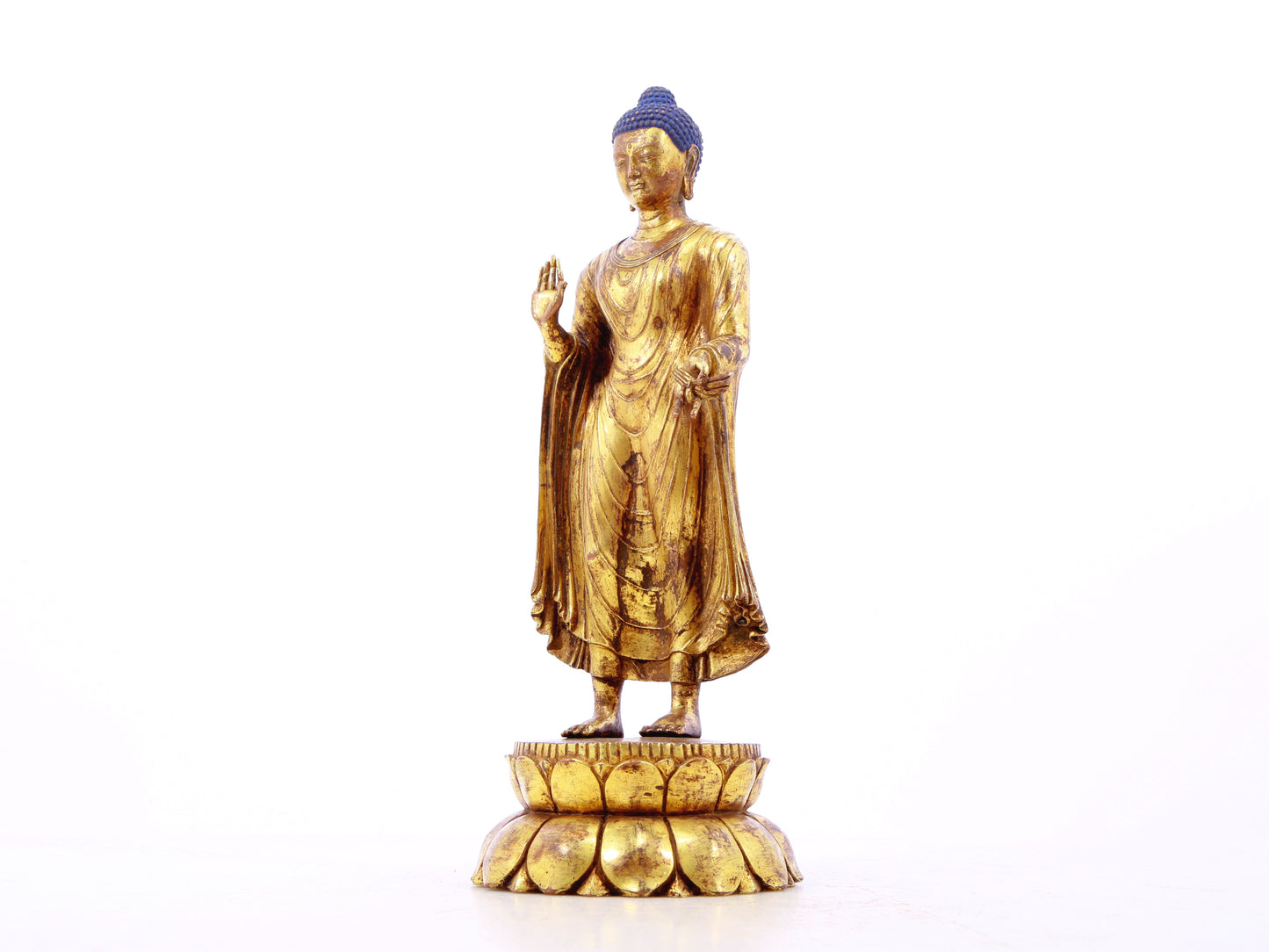 A serene gilt bronze statue of Gautama Buddha