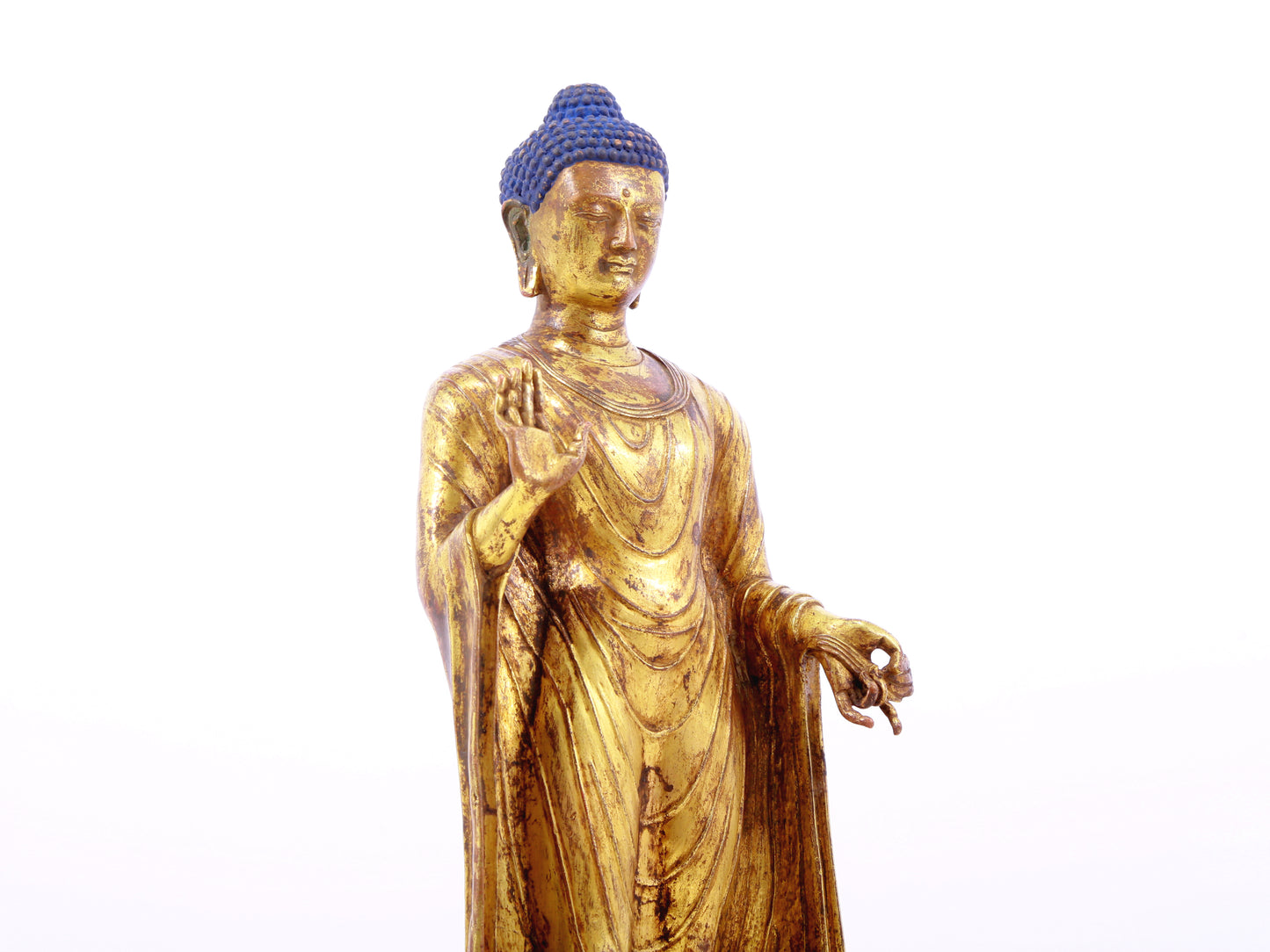 A serene gilt bronze statue of Gautama Buddha