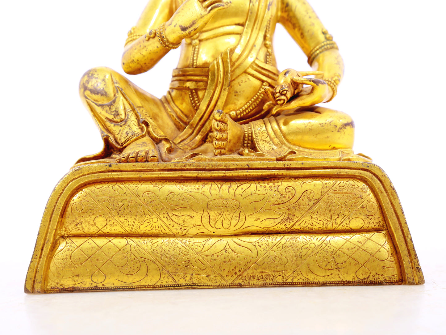 A serene gilt bronze statue of the God of Wealth