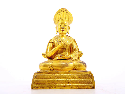 A serene gilt bronze statue of the guru