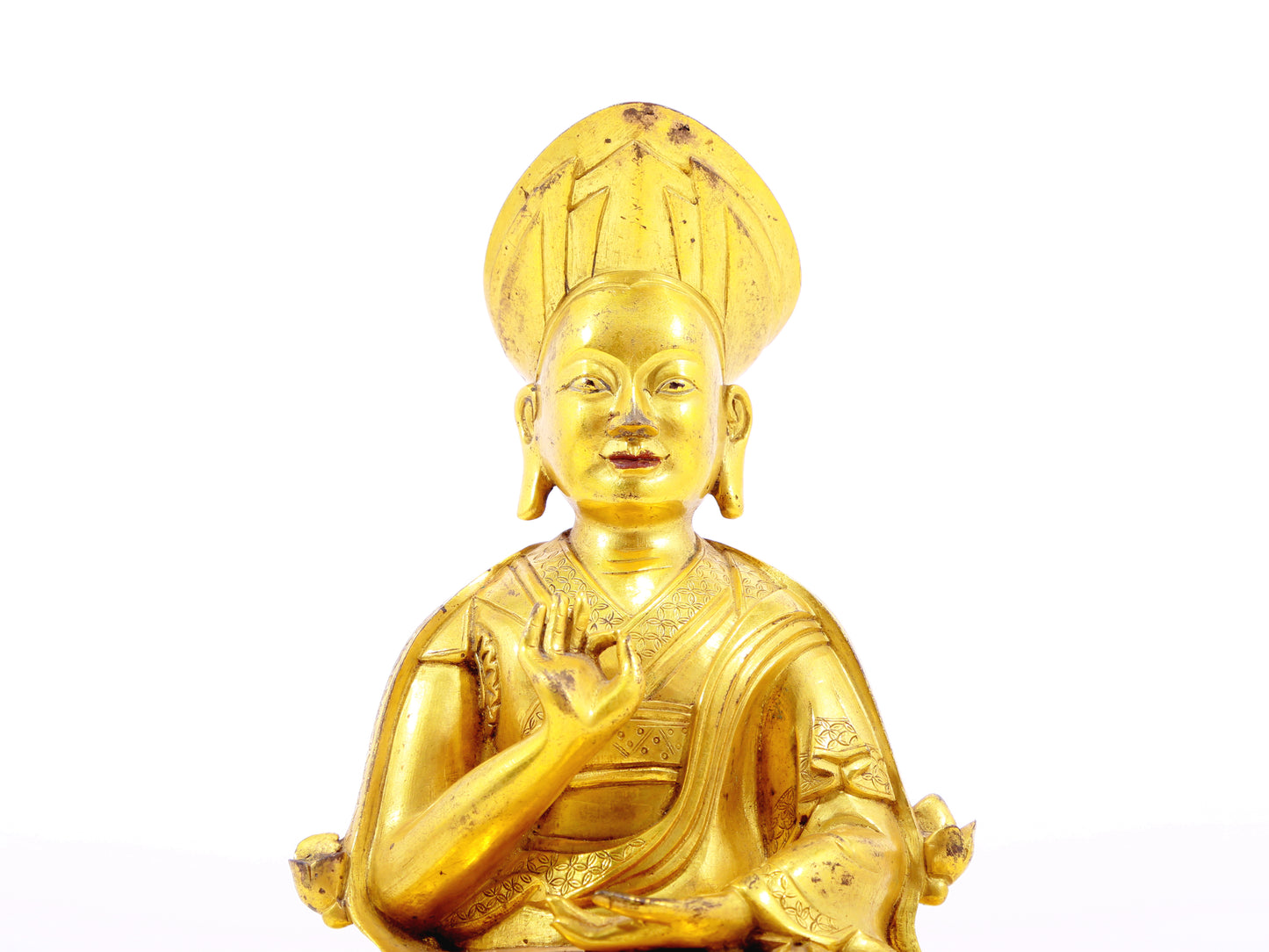 A serene gilt bronze statue of the guru