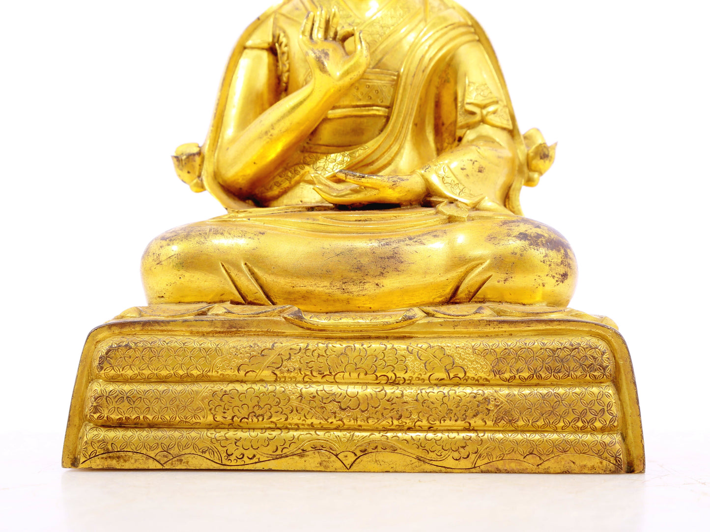 A serene gilt bronze statue of the guru