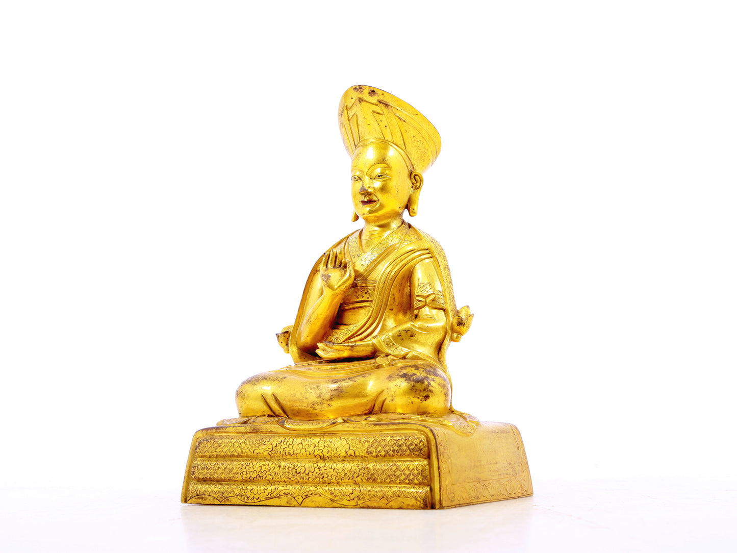 A serene gilt bronze statue of the guru