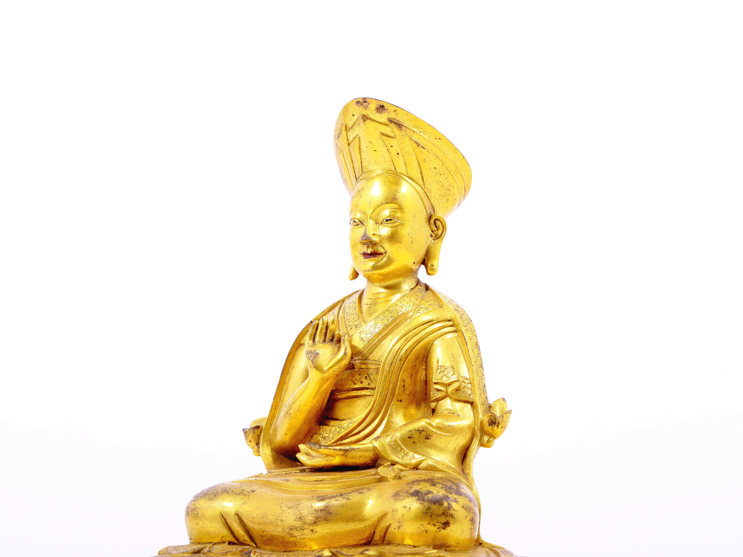 A serene gilt bronze statue of the guru