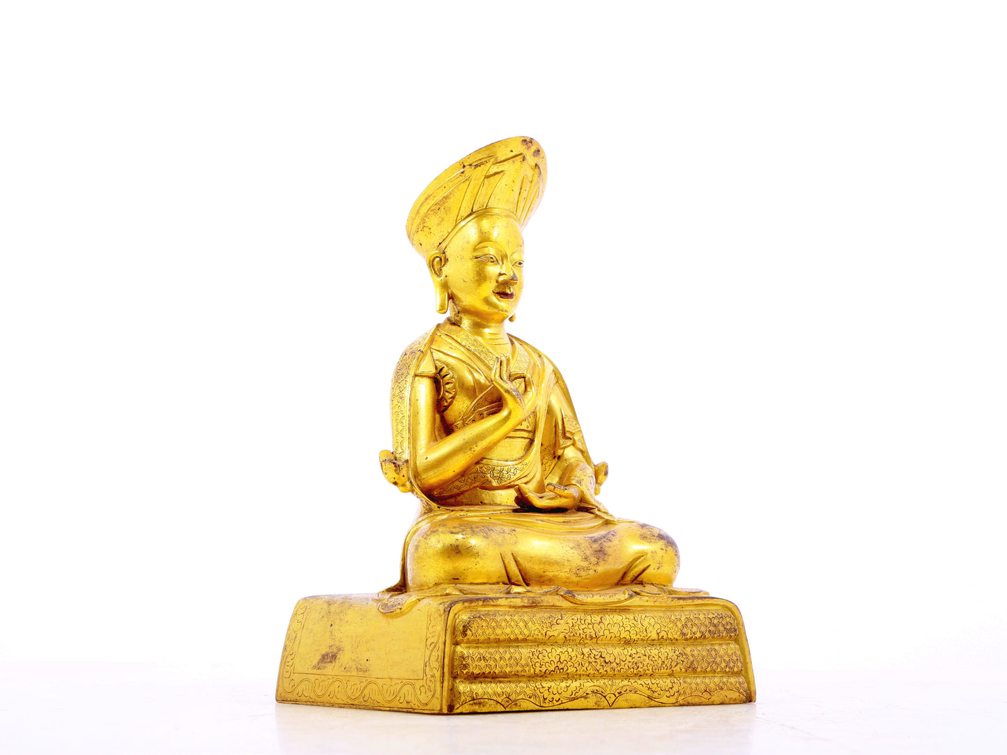 A serene gilt bronze statue of the guru