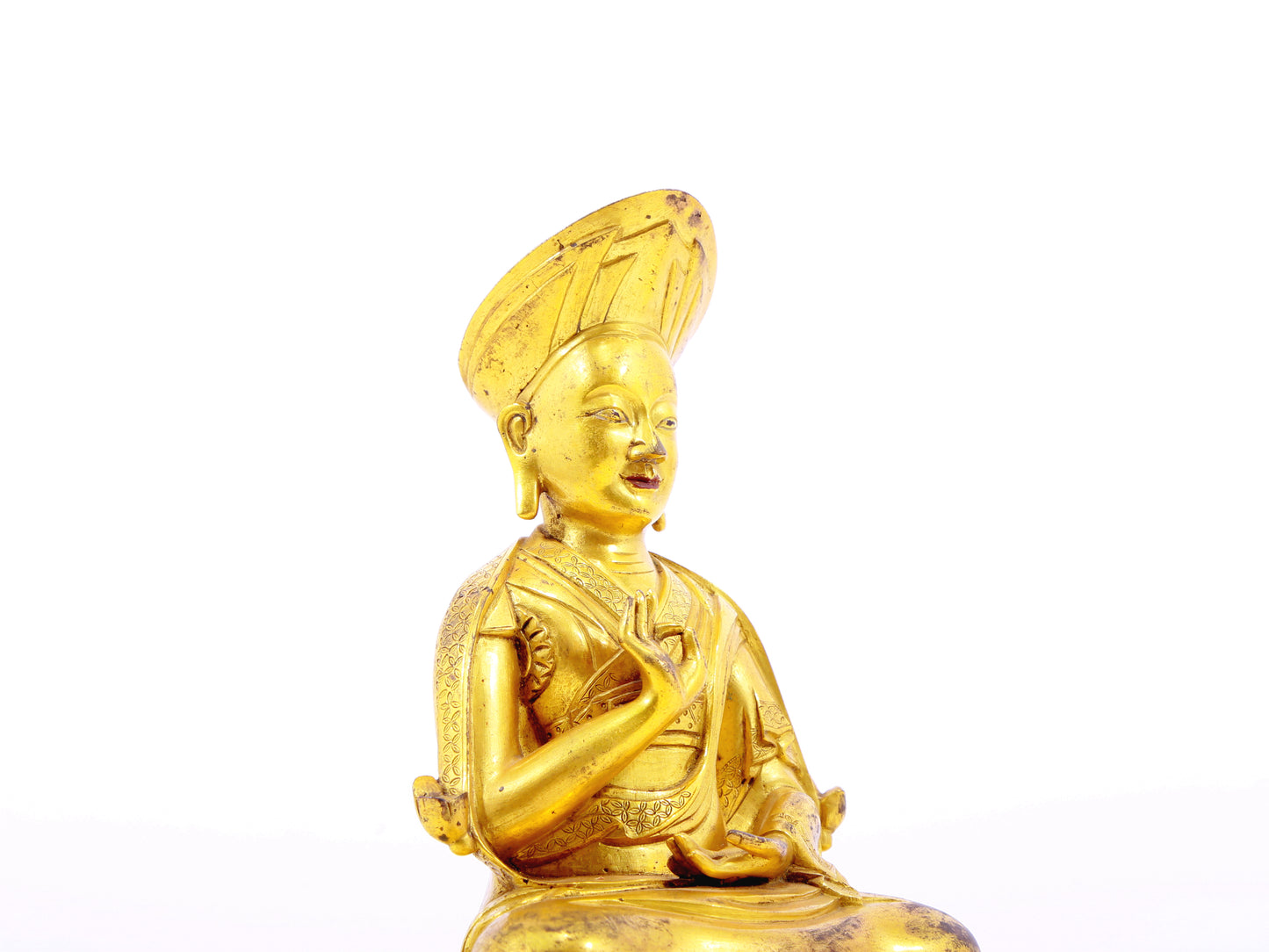 A serene gilt bronze statue of the guru