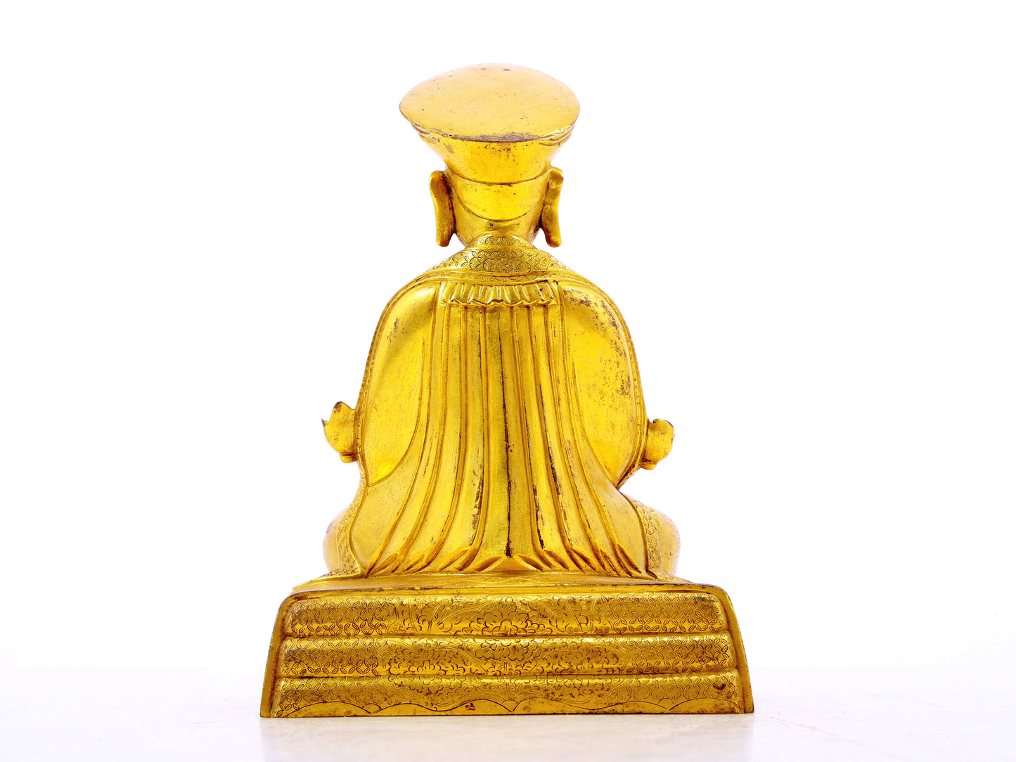 A serene gilt bronze statue of the guru