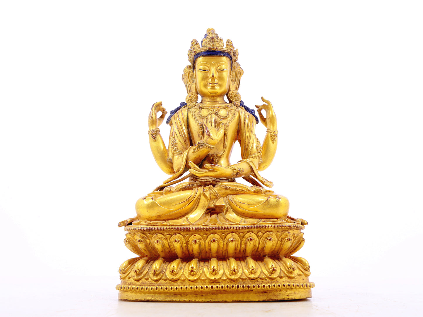 A solemn gilt bronze four-armed Guanyin statue