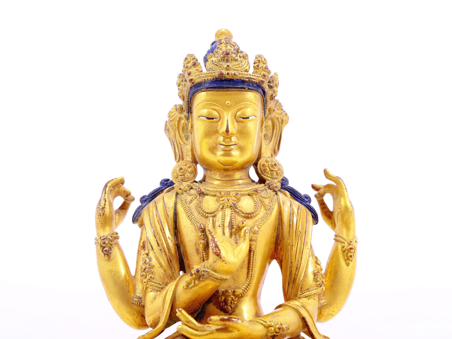 A solemn gilt bronze four-armed Guanyin statue