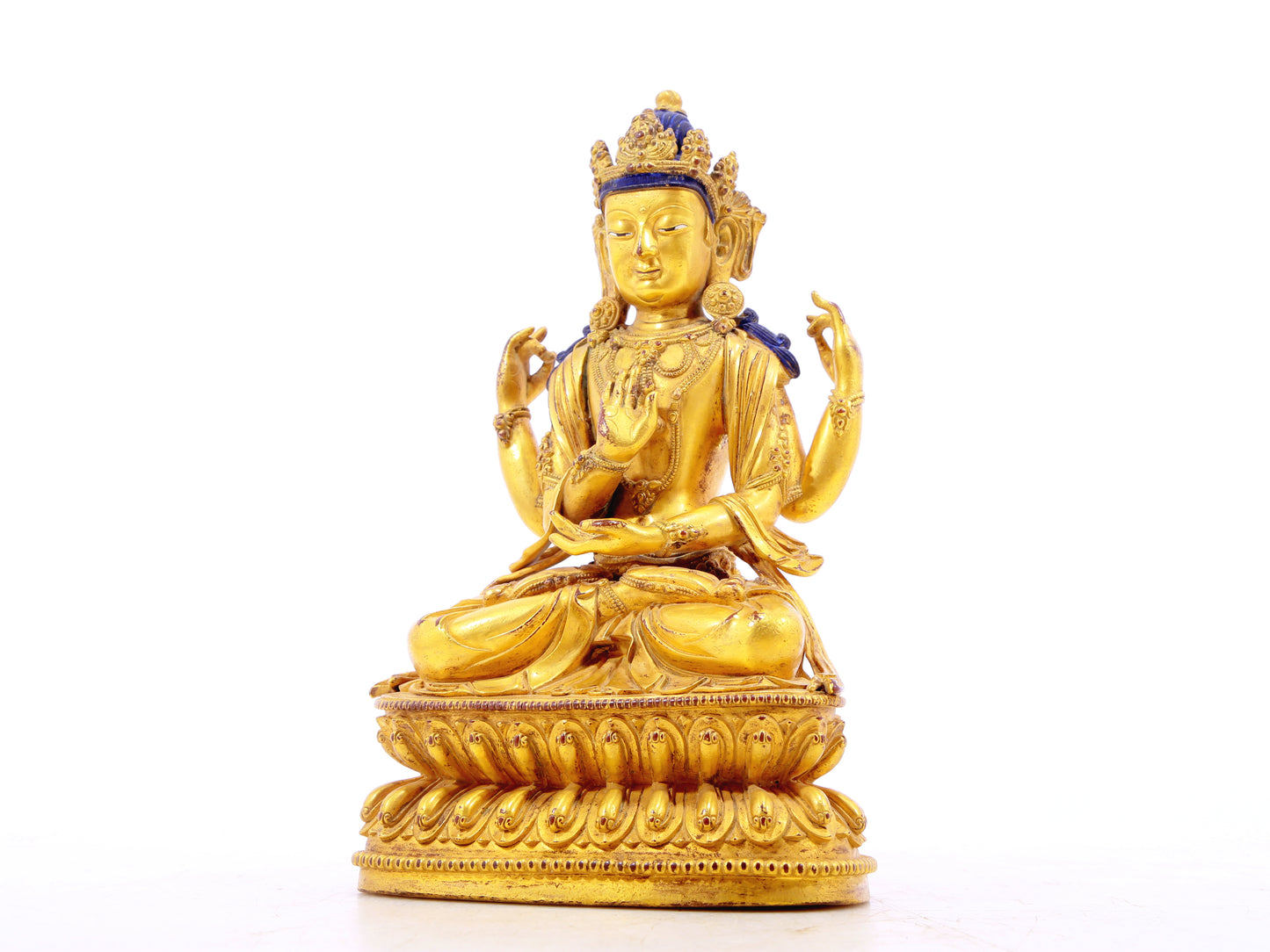 A solemn gilt bronze four-armed Guanyin statue