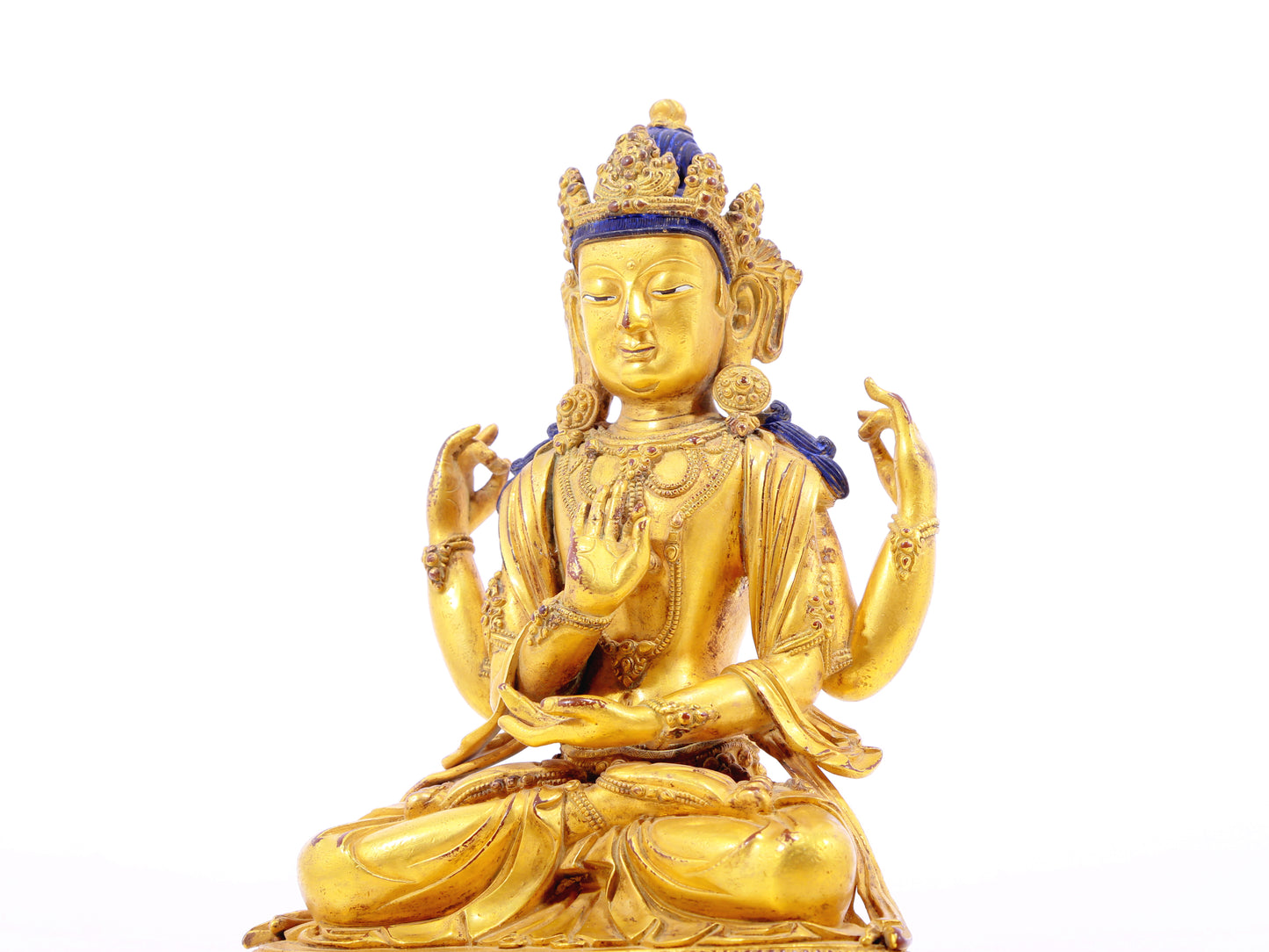 A solemn gilt bronze four-armed Guanyin statue