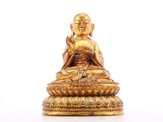 A solemn gilt bronze statue of the guru