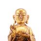 A solemn gilt bronze statue of the guru