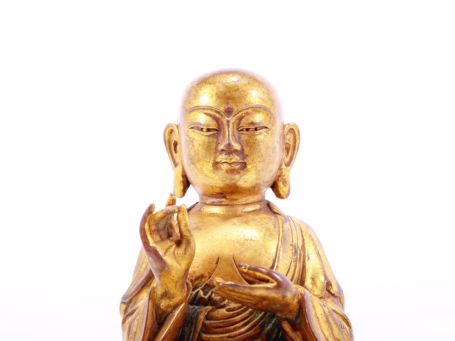 A solemn gilt bronze statue of the guru