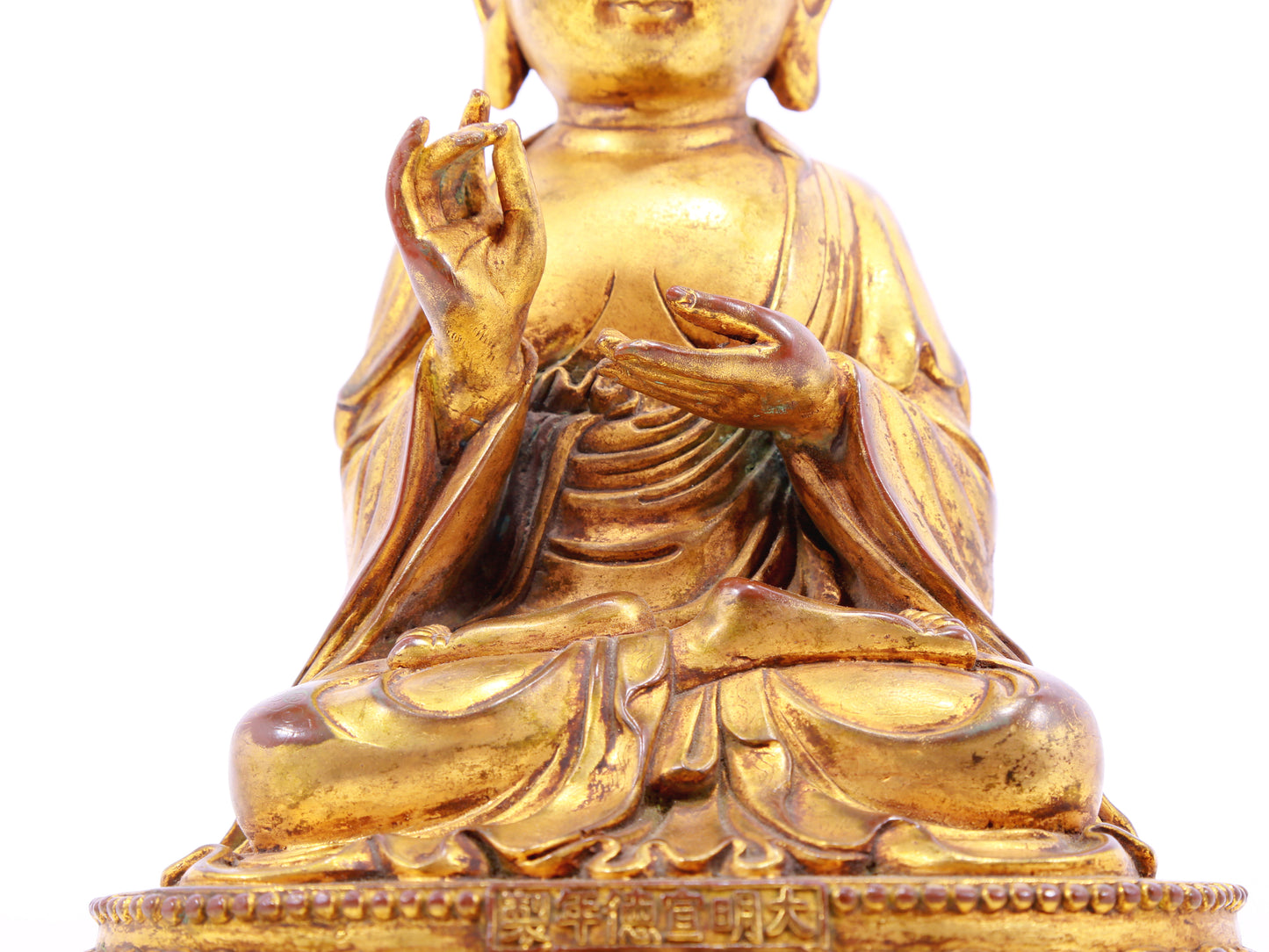 A solemn gilt bronze statue of the guru