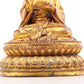 A solemn gilt bronze statue of the guru