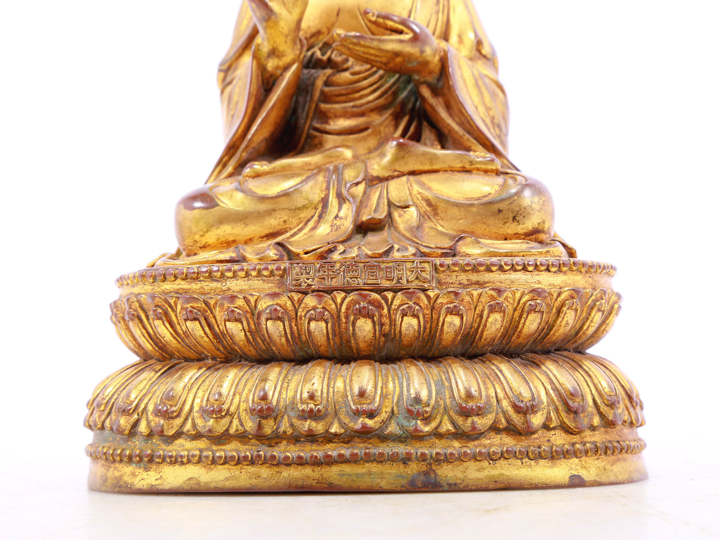 A solemn gilt bronze statue of the guru