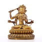 A serene gilt bronze statue of Manjusri with four arms