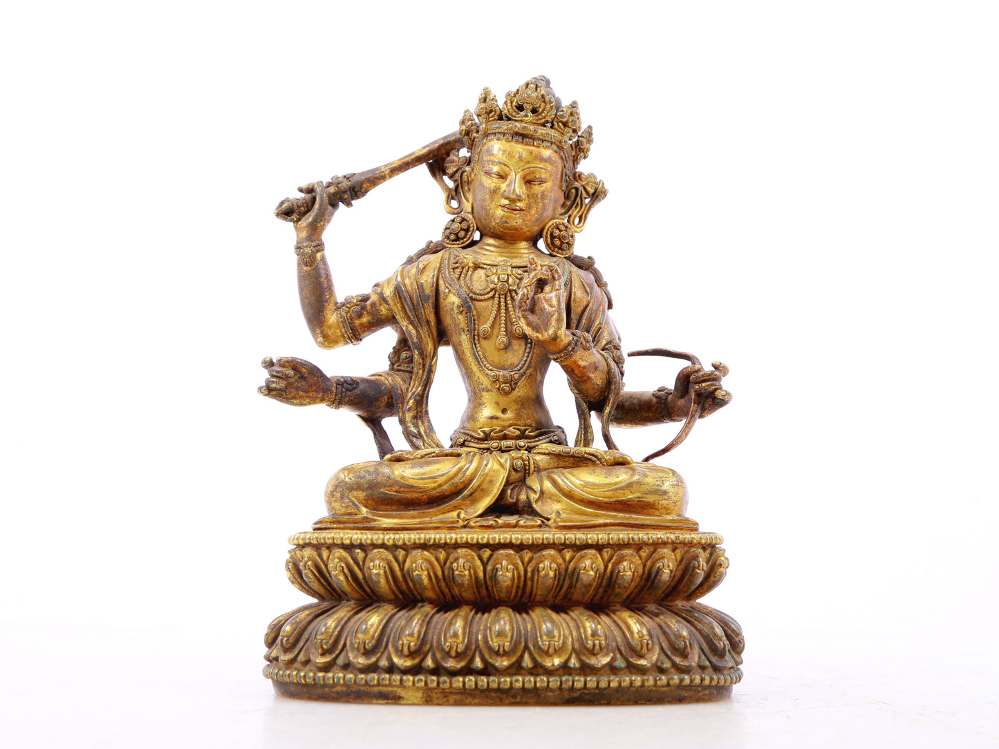 A serene gilt bronze statue of Manjusri with four arms