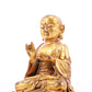 A solemn gilt bronze statue of the guru