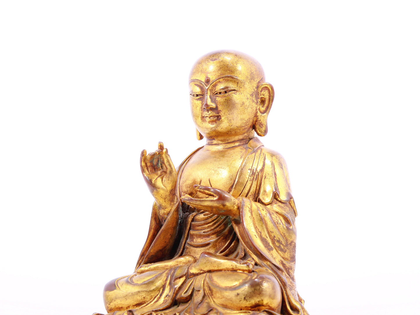 A solemn gilt bronze statue of the guru